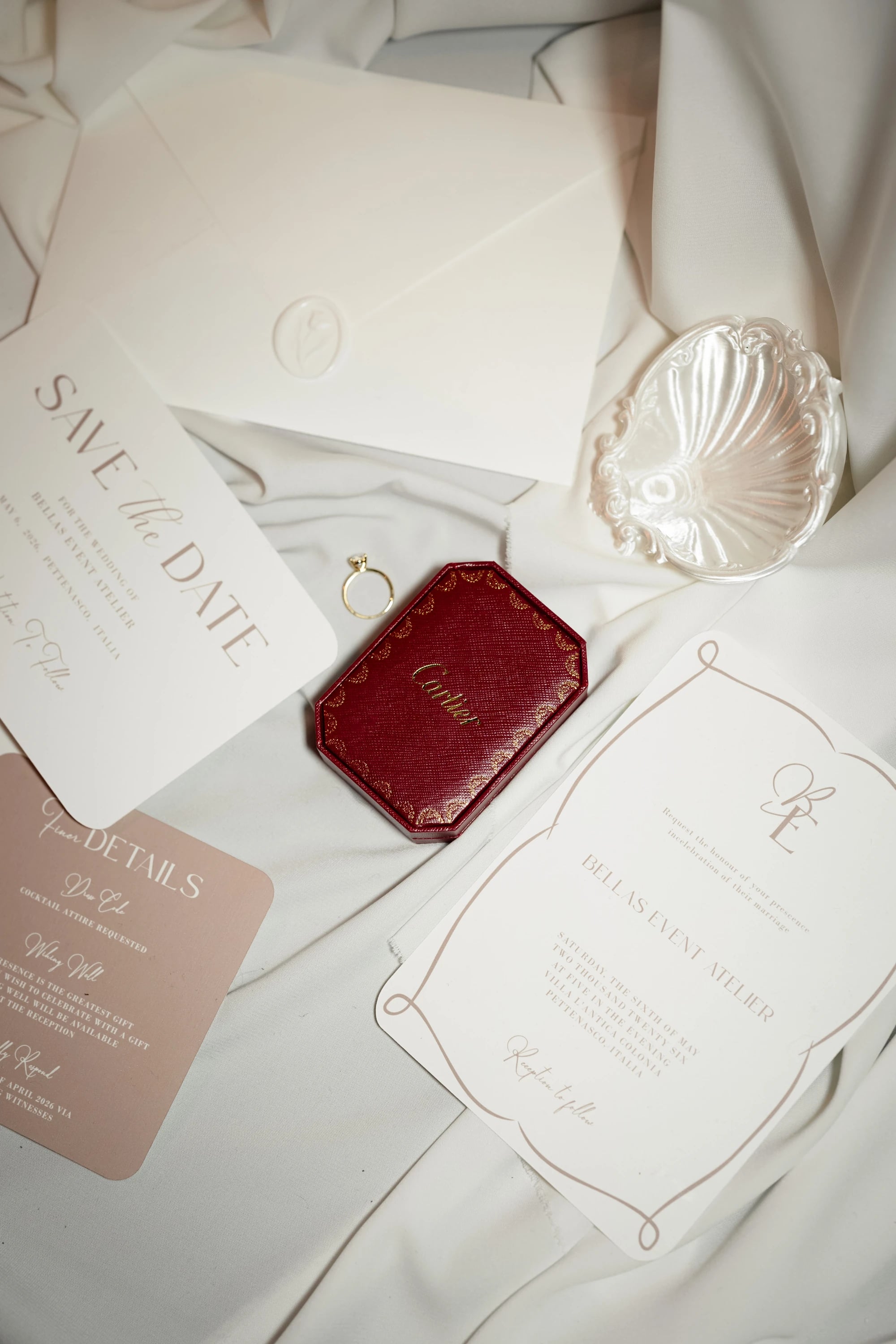 Save-the-Date-Karten und die Ringschatulle auf hellem Stoff